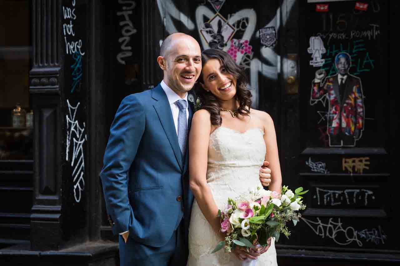 Portrait of bride and groom against graffiti for an article on non-floral centerpiece ideas