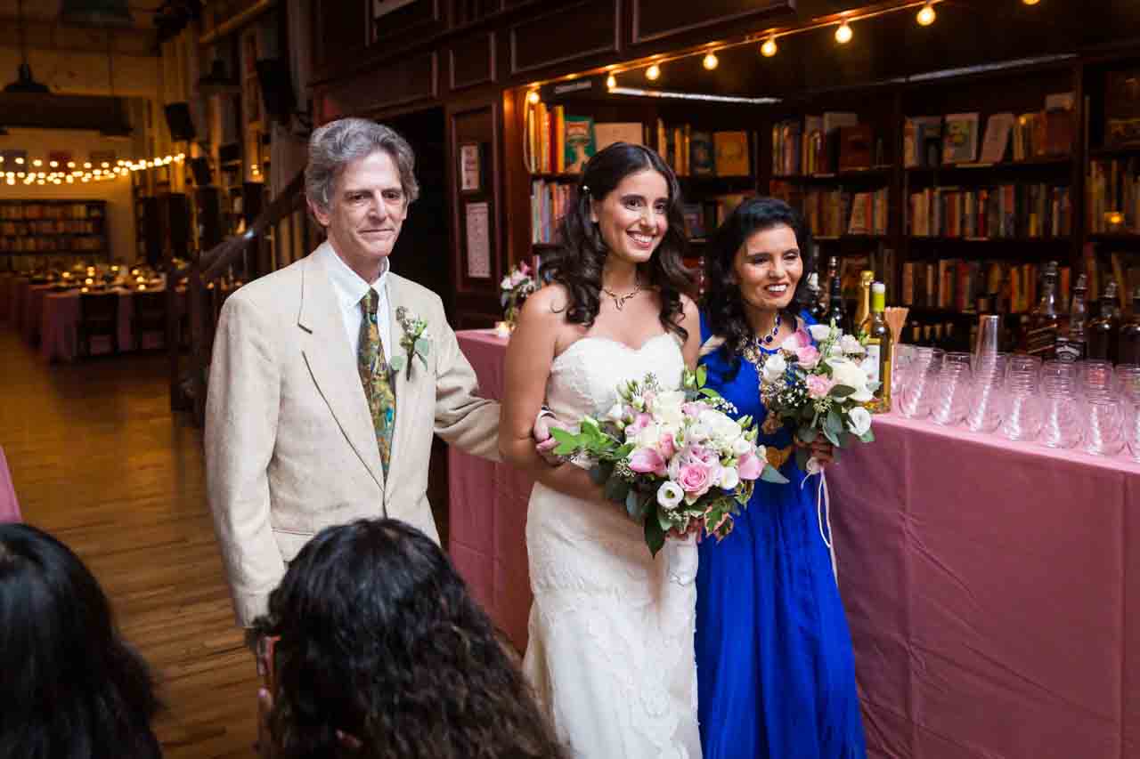 Bride and parents coming down aisle for an article on non-floral centerpiece ideas