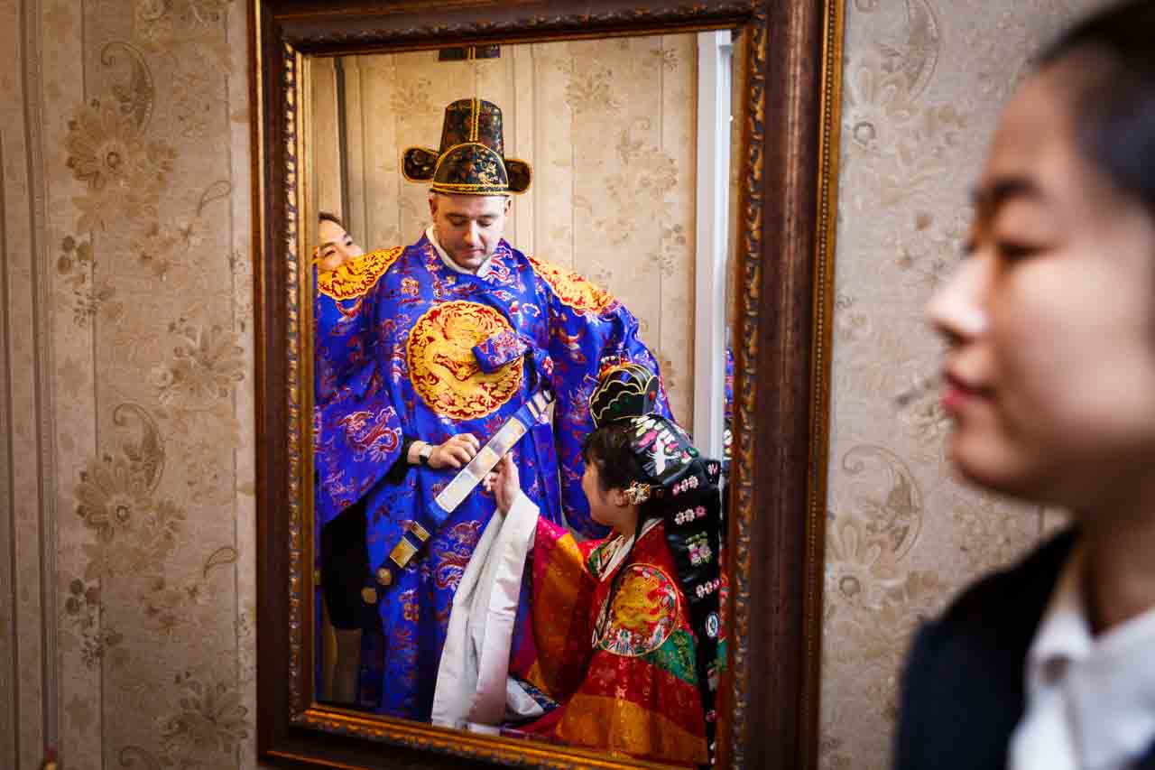 Bride and groom in mirror at traditional Korean pyebaek ceremony