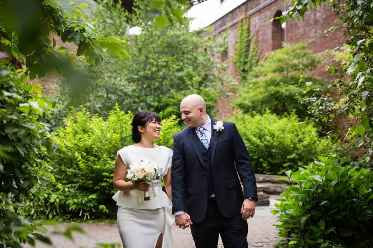 Bride and groom walking close in Brooklyn Bridge Park