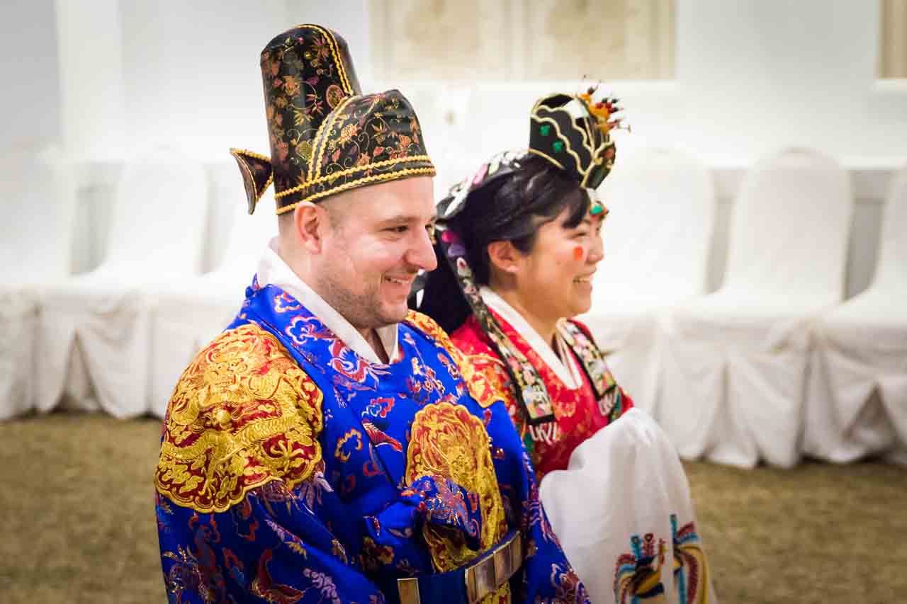 Bride and groom laughing at traditional Korean pyebaek ceremony