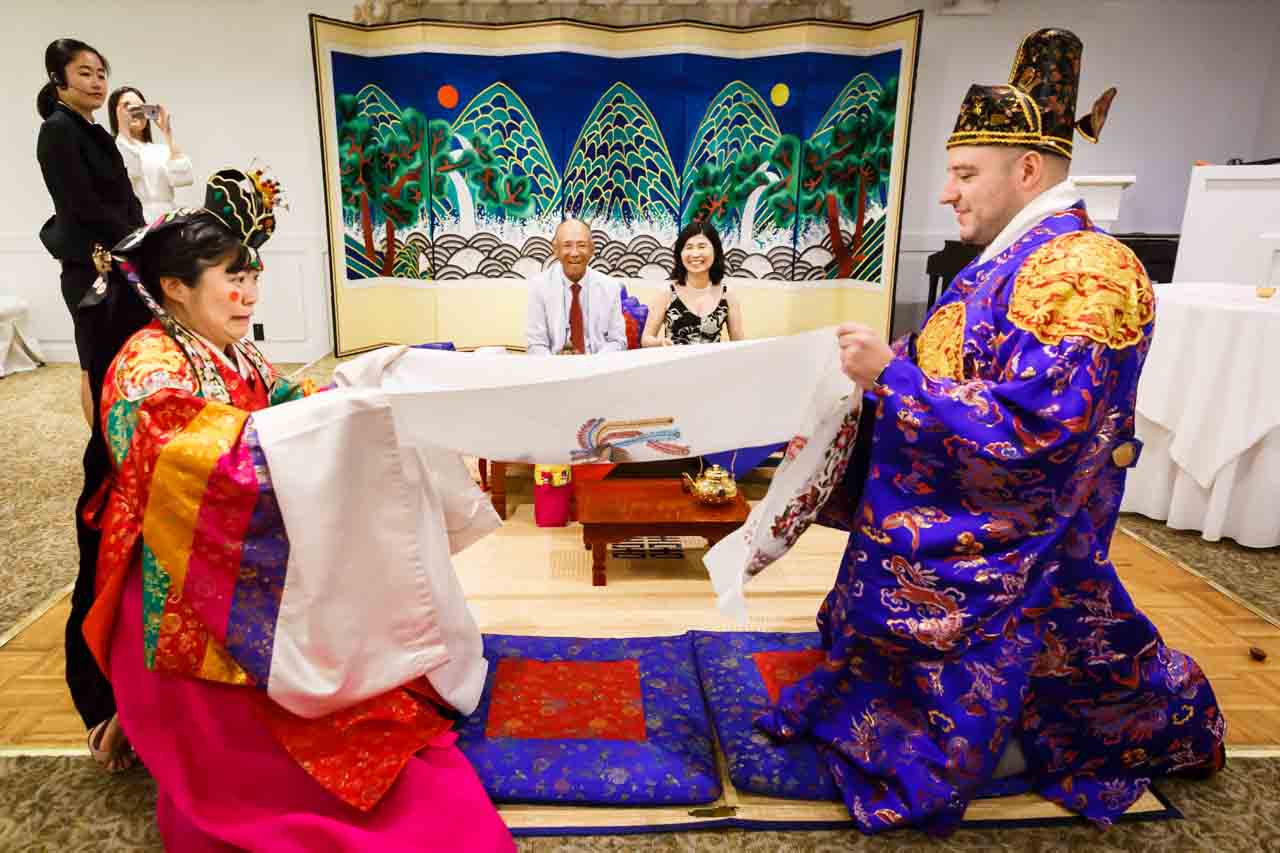 Bride and groom catching jujubes at traditional Korean pyebaek ceremony