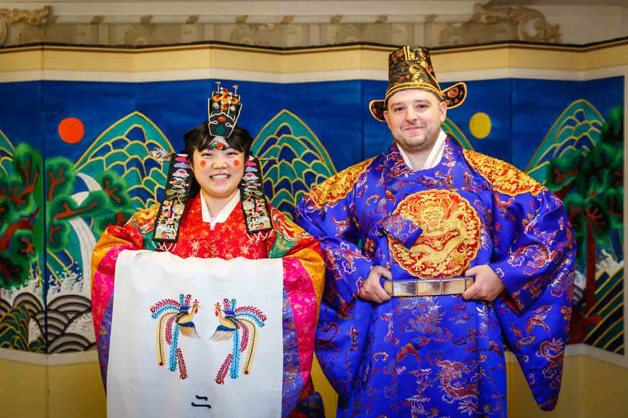 Formal portrait of bride and groom wearing hanbok at traditional Korean pyebaek ceremony