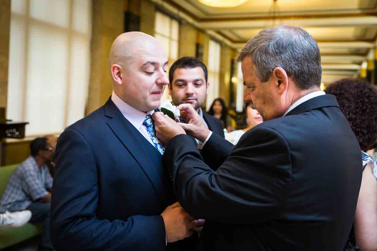 Father adjusting groom's boutonniere