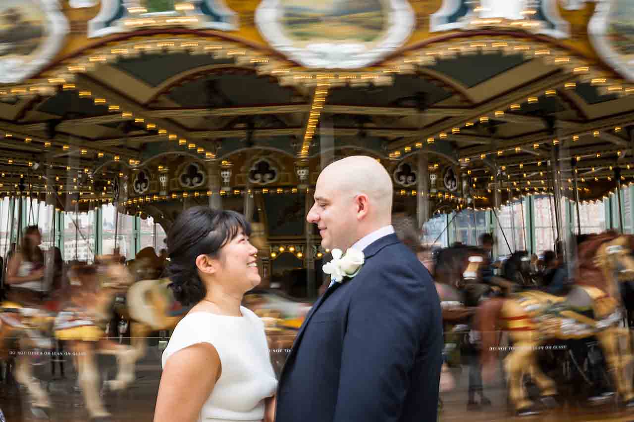 Bride and groom in front of spinning carousel