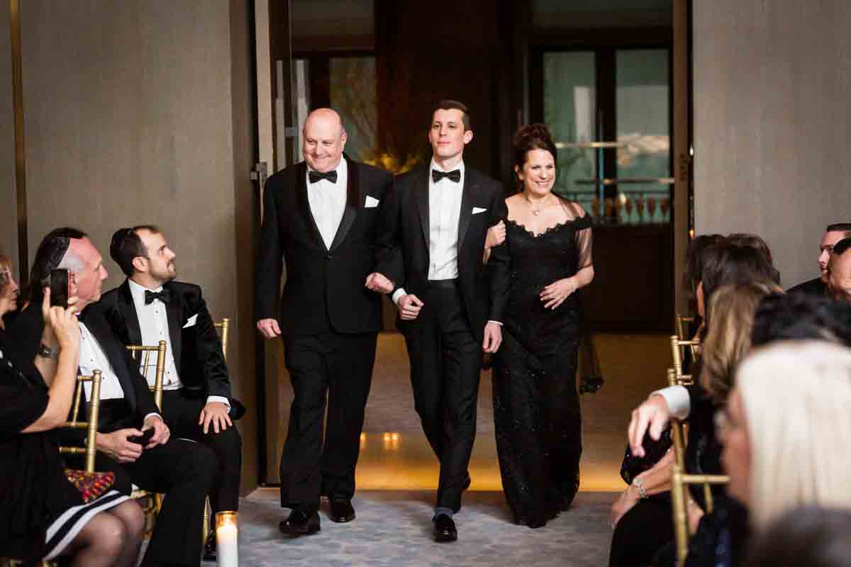 Groom and parents walking down the aisle at a Four Seasons Hotel New York Downtown wedding