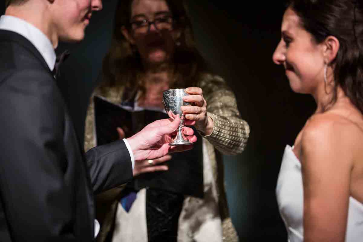Cantor handing kiddush cup to groom during Four Seasons Hotel New York Downtown wedding