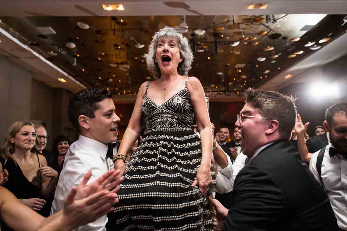 Mother of the bride lifted in a chair during hora dance at a Four Seasons Hotel New York Downtown wedding