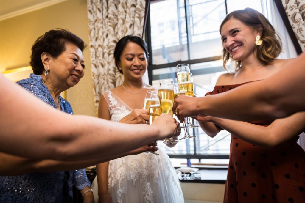 Bride, mother, and bridesmaids toasting with glasses of champagne