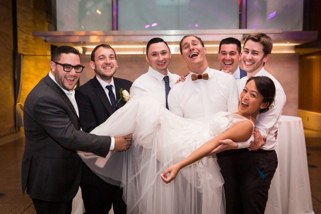 Bride lifted in the air by groomsmen at at Bronx Zoo wedding