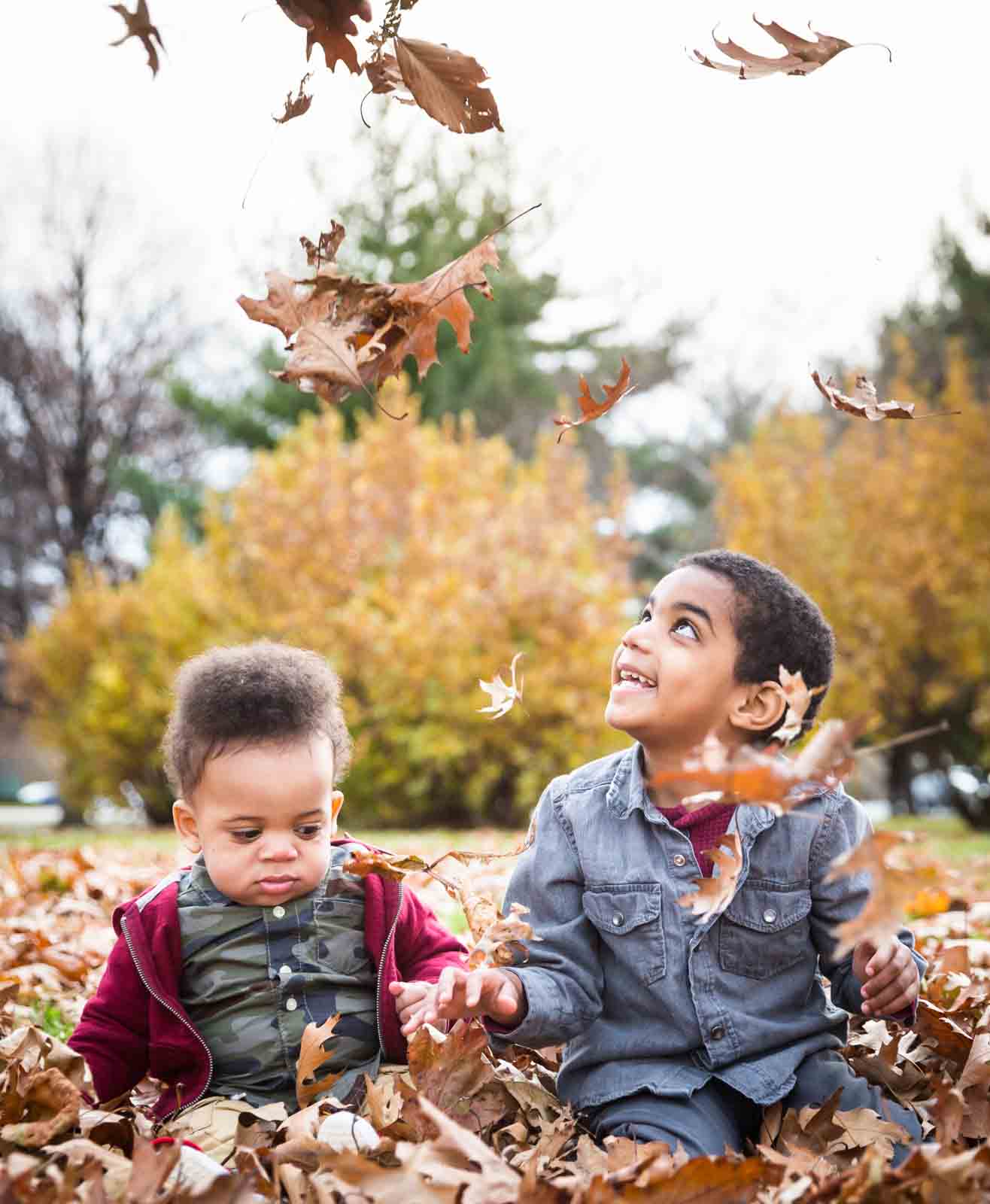 Flushing Meadows Corona Park family portrait of two little boys playing in fall leaves