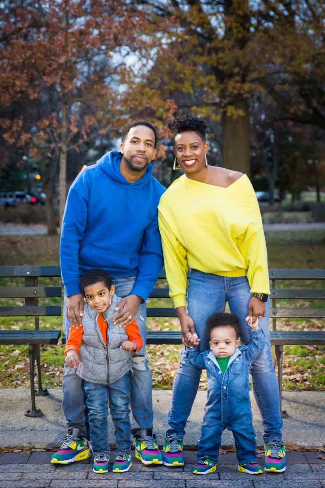 Flushing Meadows Corona Park family portrait of parents and two children wearing brightly colored clothes