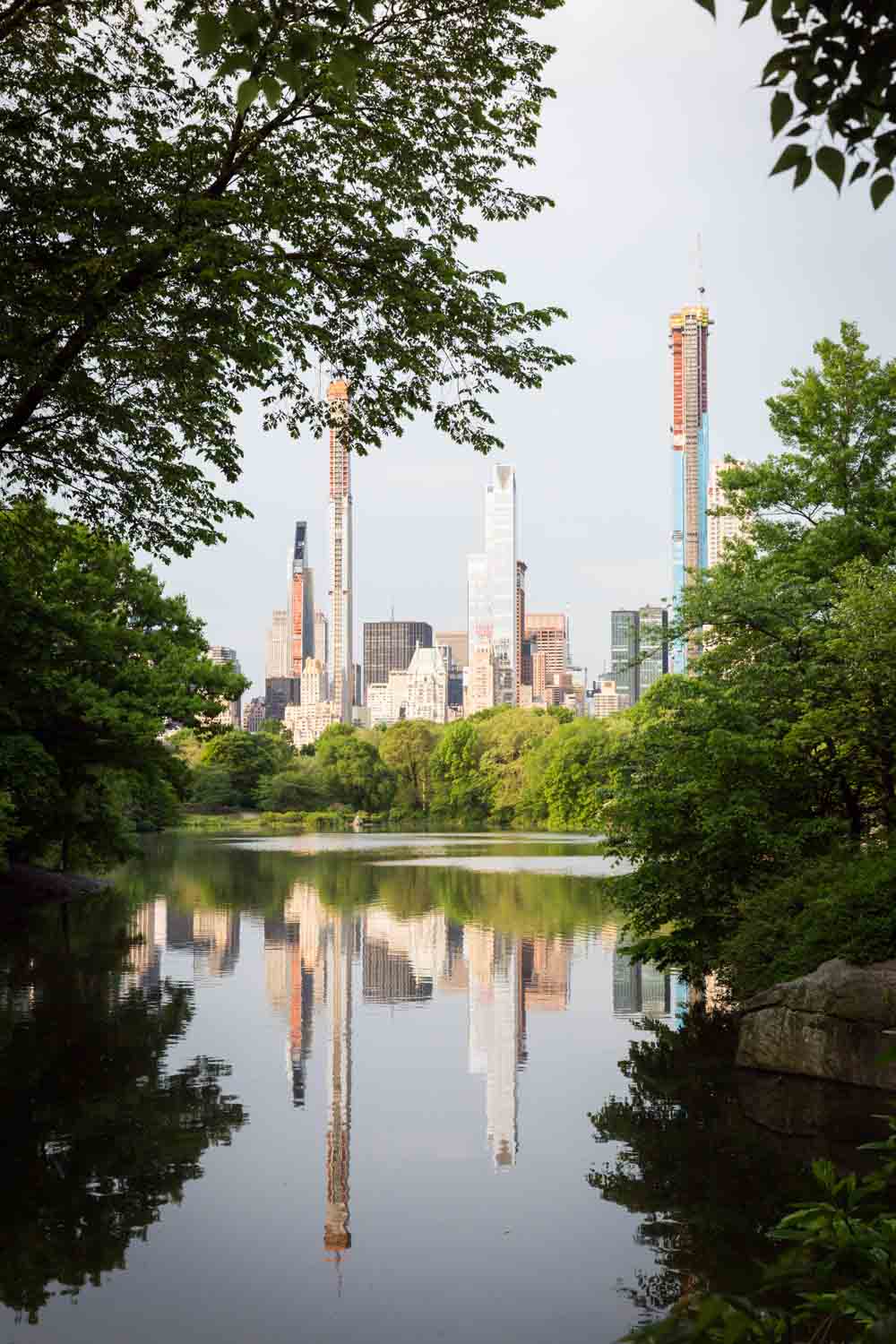 View of NYC skyline across Central Park lake