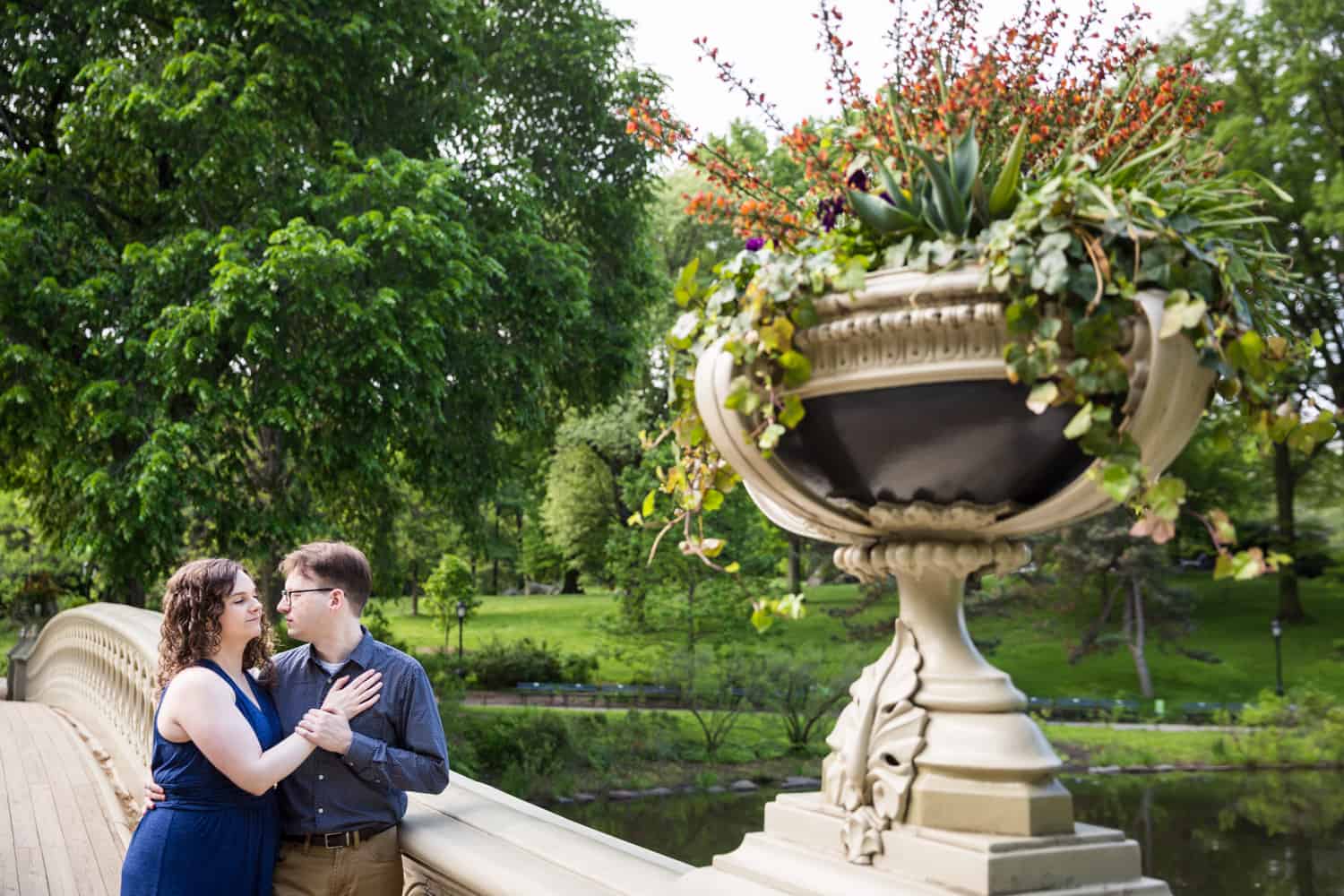 Couple hugging on Bow Bridge for Shakespeare Garden engagement photos