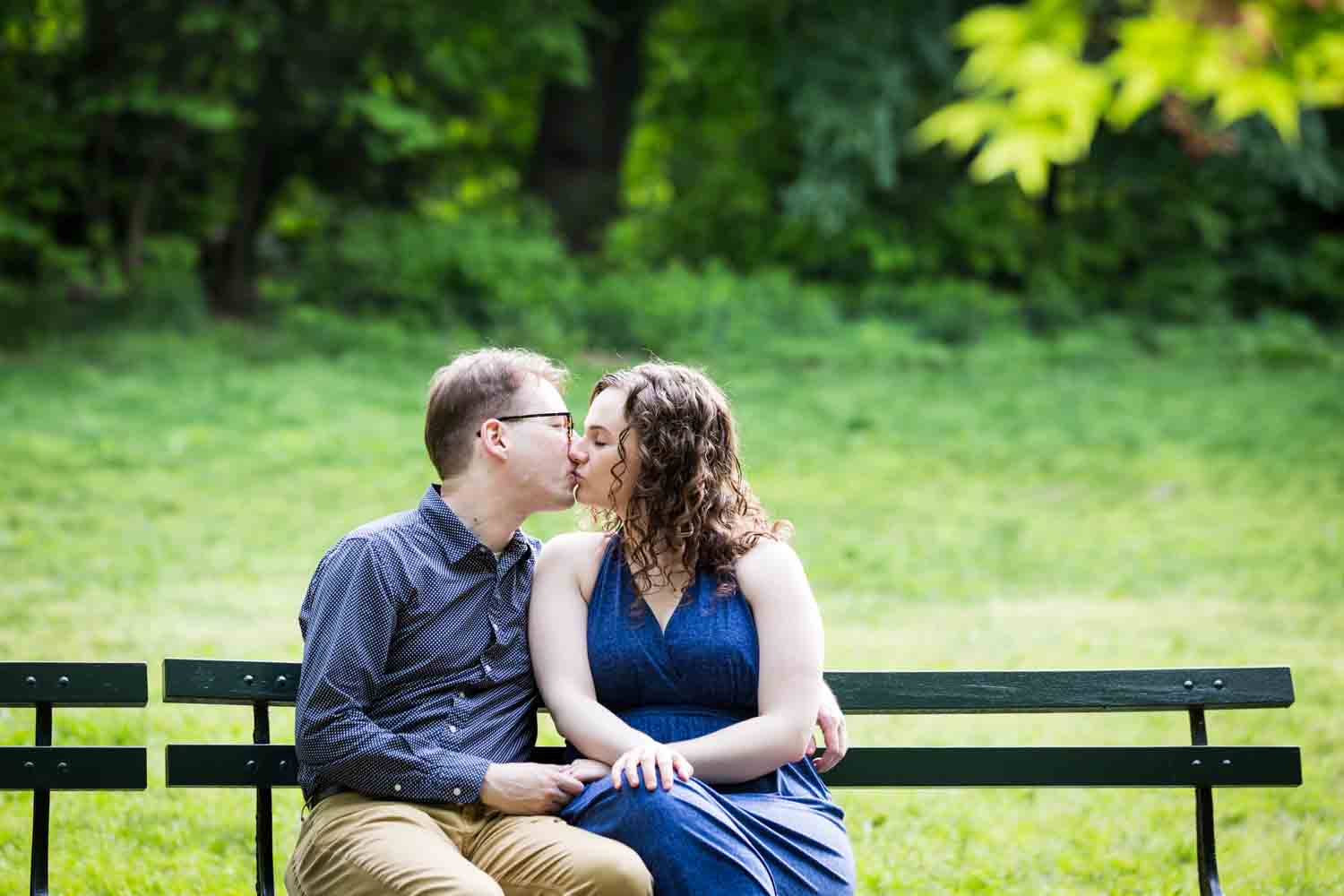 Man and woman kissing on bench in Central Park