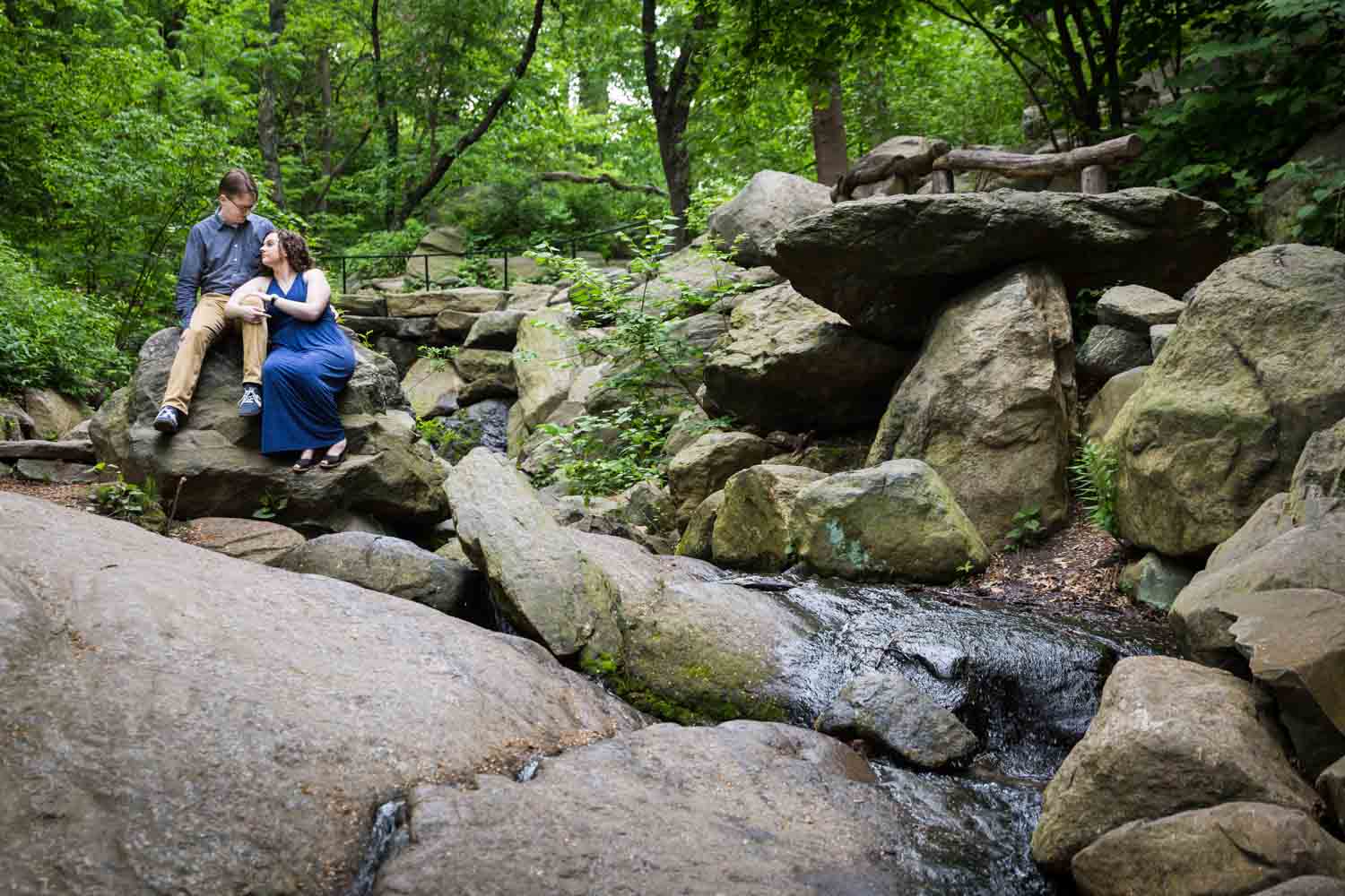 Couple sitting on boulders beside waterfall in Central Park