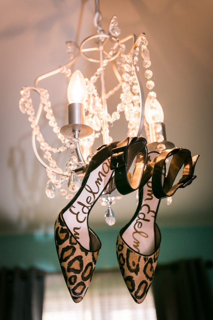Pair of leopard print Sam Edelman heels hanging in a chandelier