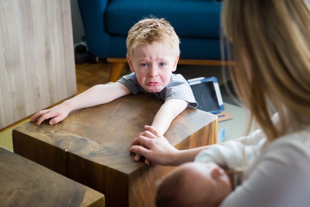 Little boy about to cry and sitting at table
