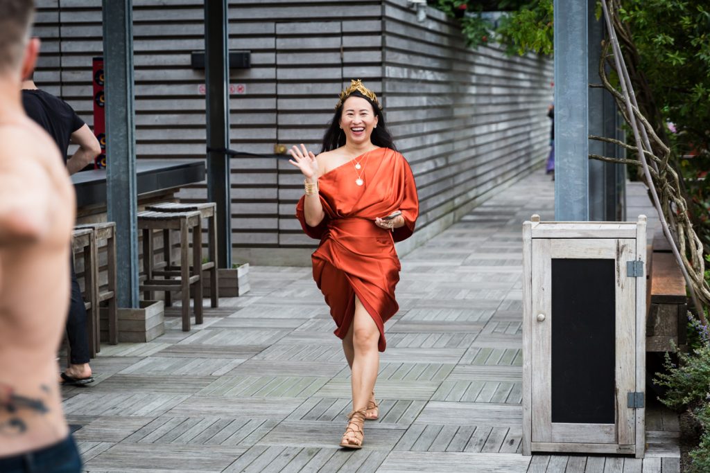 Birthday party photography of woman in orange wrap dress walking