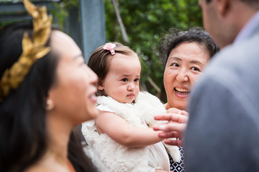 Birthday party photography of woman holding unhappy baby