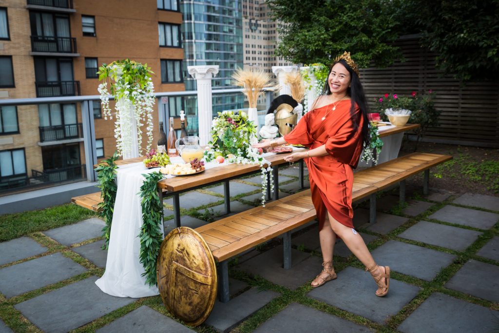 Birthday party photography of woman in orange dress posed by food buffet