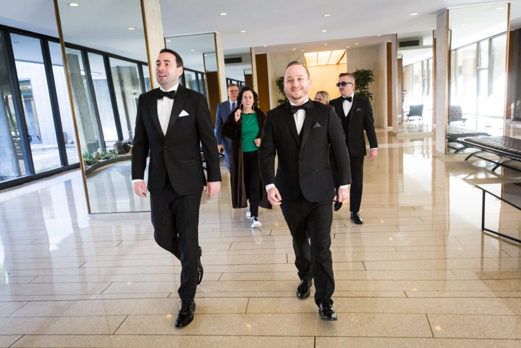 Groom and bridal party walking in apartment lobby at a Water Club wedding