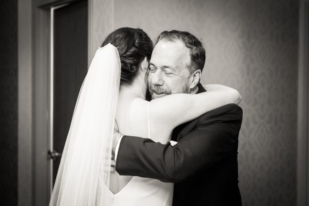 Black and white photo of father hugging bride