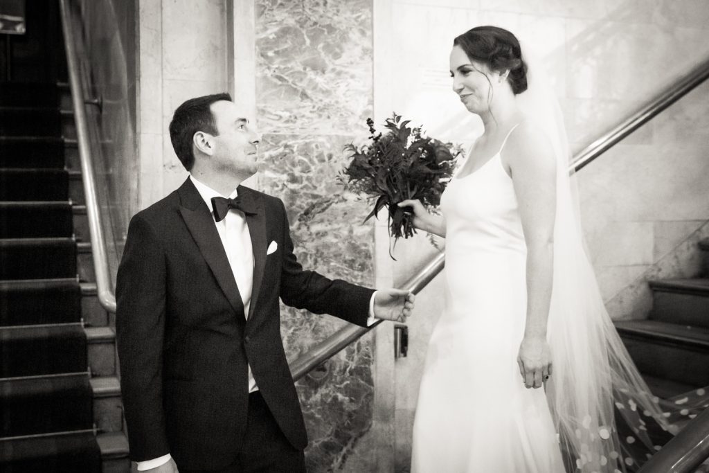 Black and white photo of groom seeing bride for first time at first look
