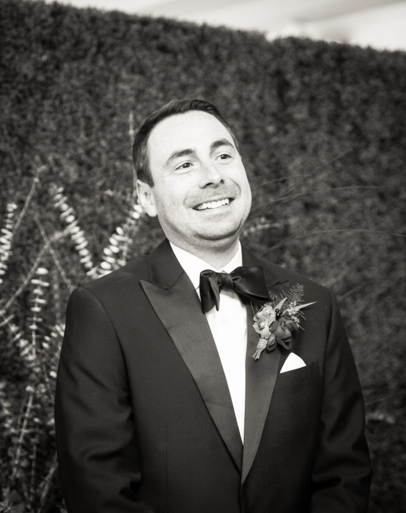 Black and white photo of groom waiting for bride at a Water Club wedding