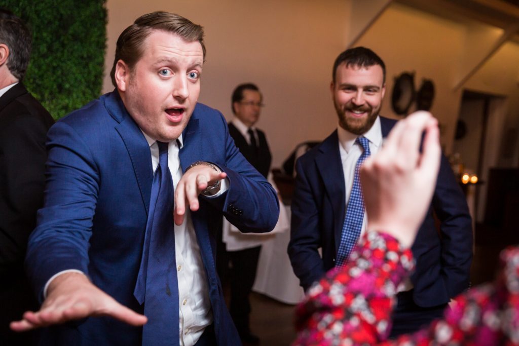 Man wearing blue blazer dancing with arms to the camera