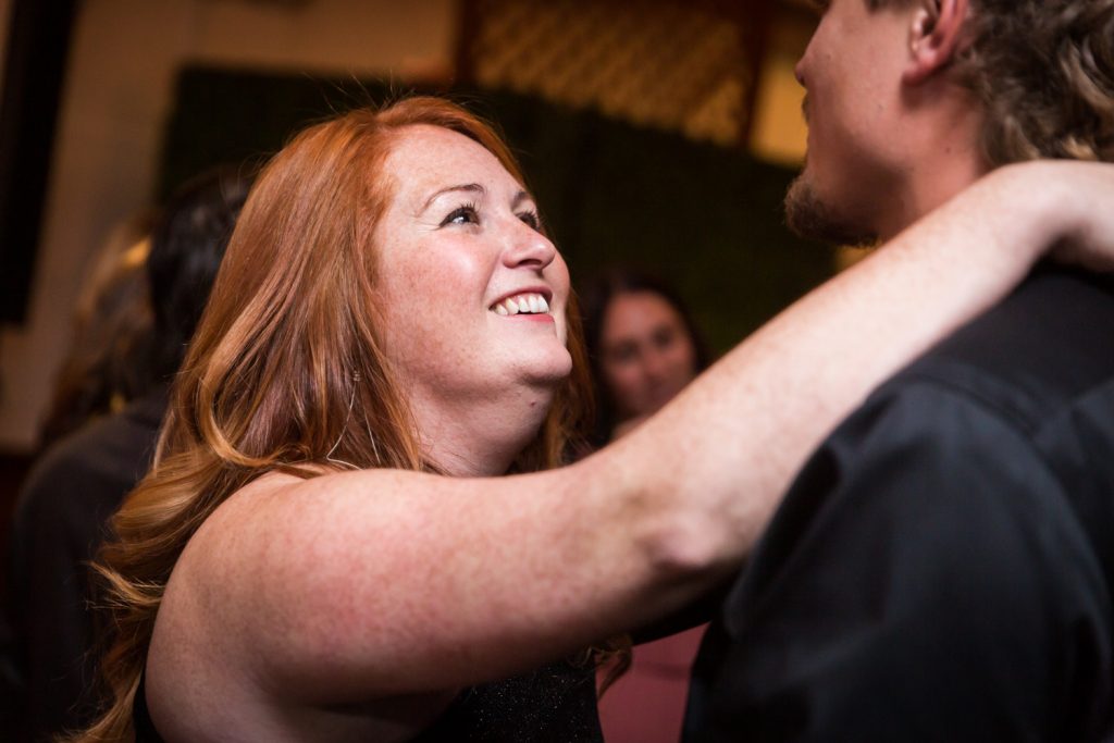 Red haired woman reaching to other guest at a Water Club wedding