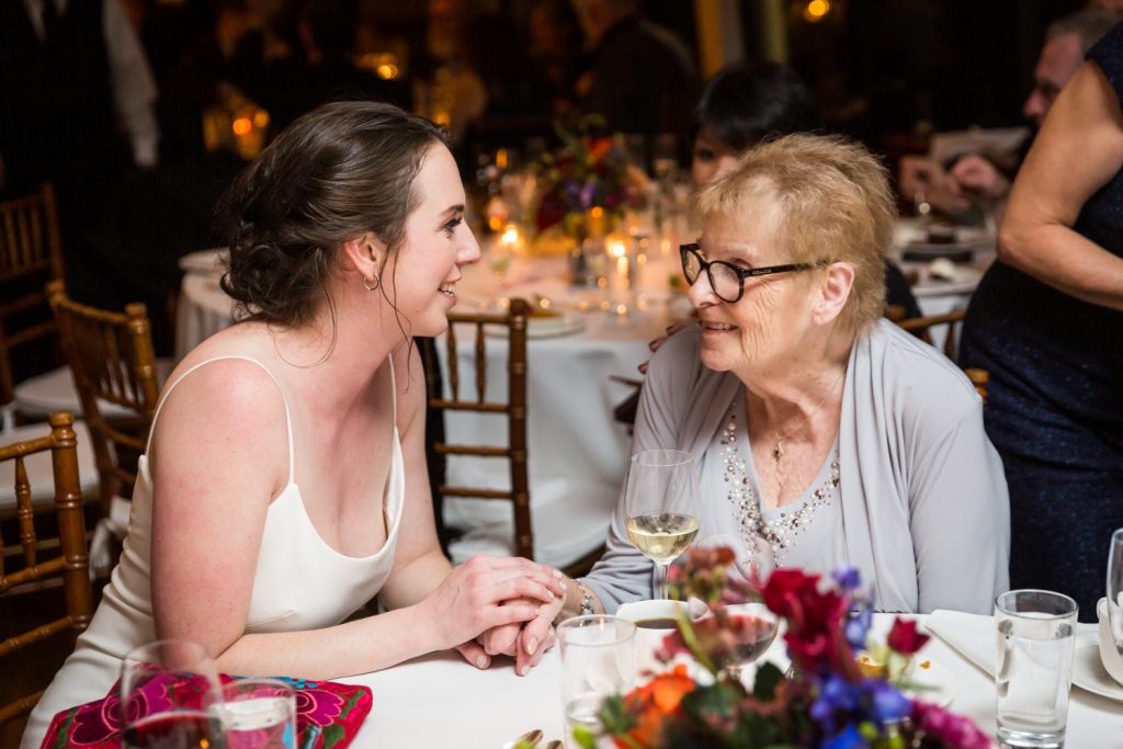 Bride holding hands with elderly guest at a Water Club wedding