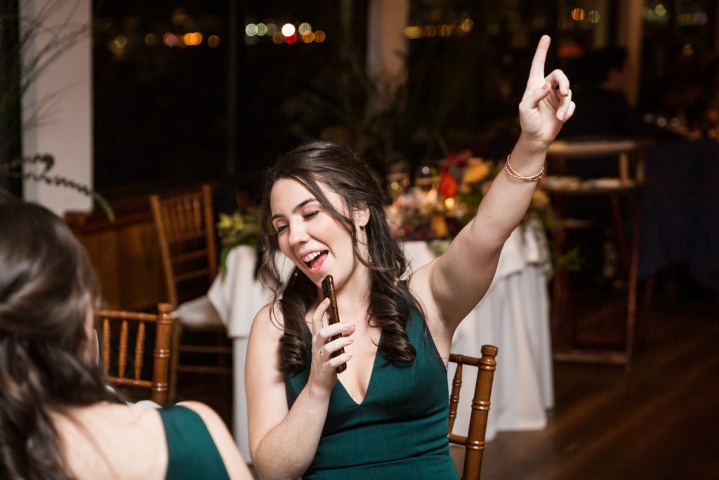 Bridesmaid singing into her cell phone at a Water Club wedding