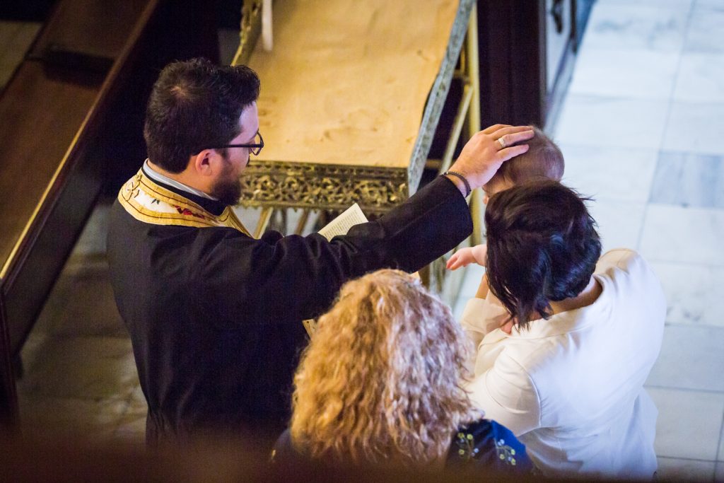 Greek orthodox baptism photos of priest with hand on baby
