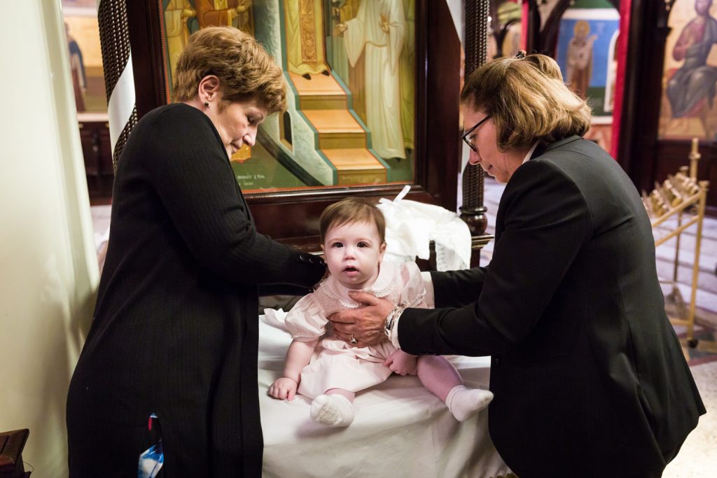 Greek orthodox baptism photos of godparents dressing baby