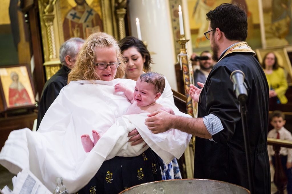 Greek orthodox baptism photos of baby being put into towel