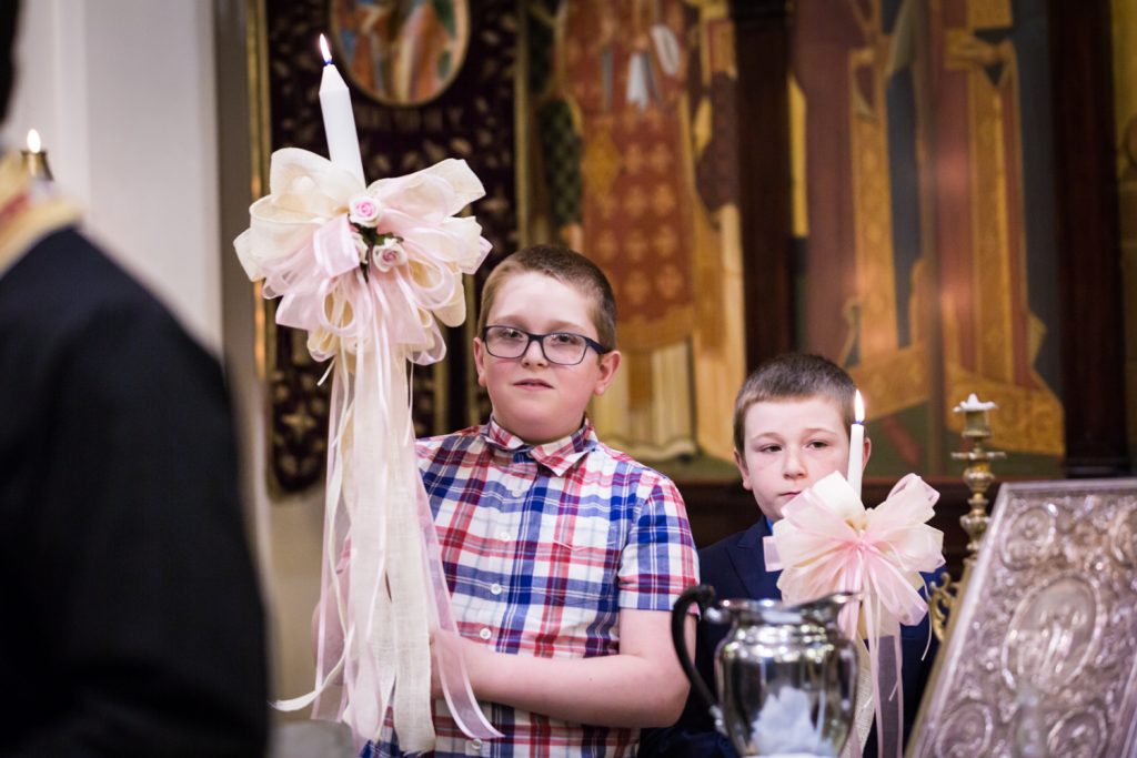 Greek orthodox baptism photos of two boys holding candles with bows