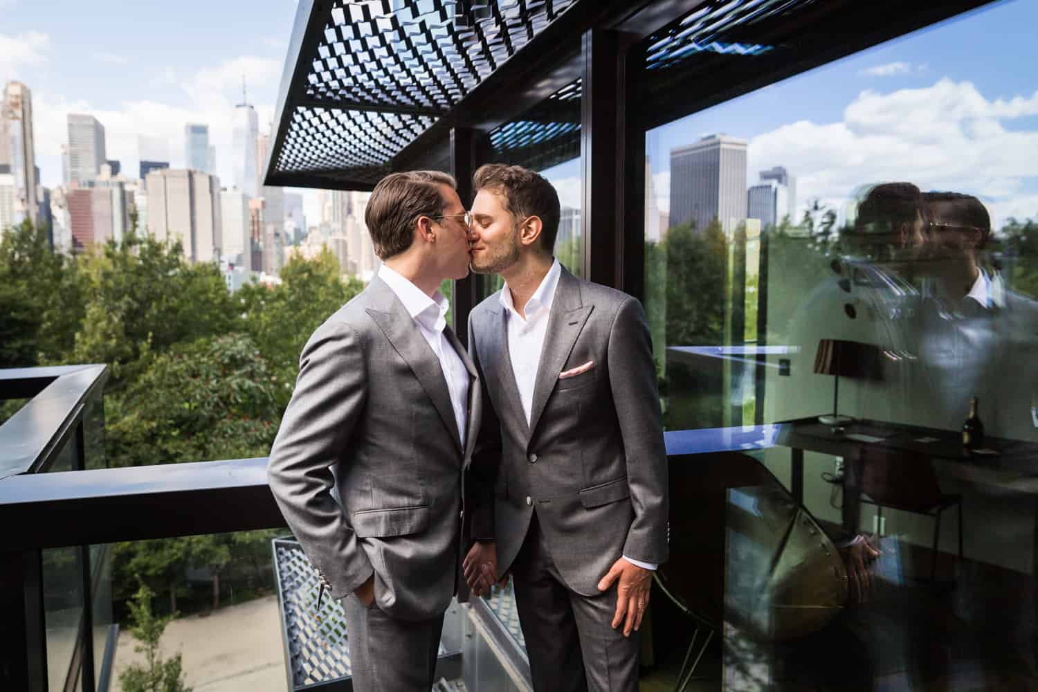 Greenpoint Loft wedding photos of two grooms kissing on hotel terrace