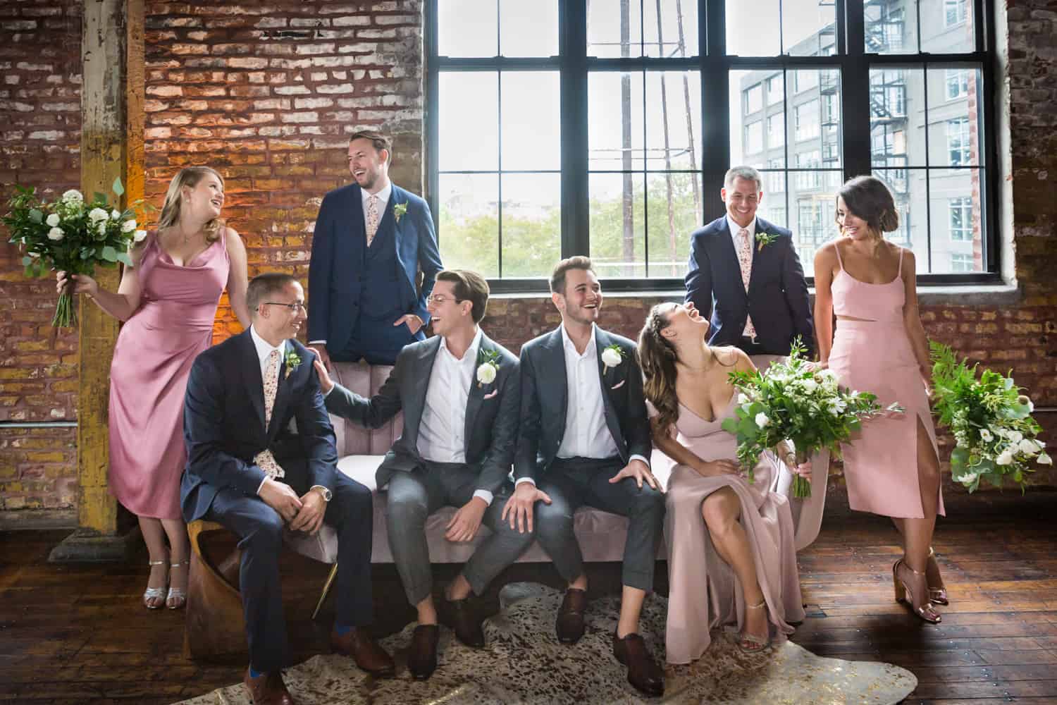 Greenpoint Loft wedding photos of bridal party lounging over couch with window in background