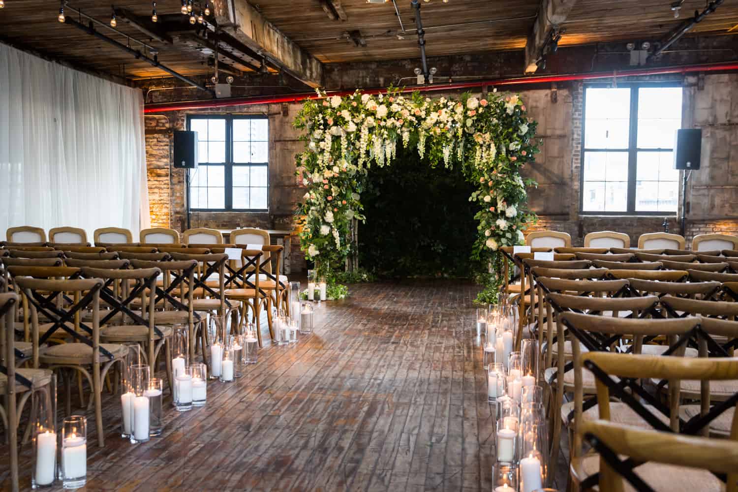 Wedding ceremony room at the Greenpoint Loft with blooming altarpiece and lit candles