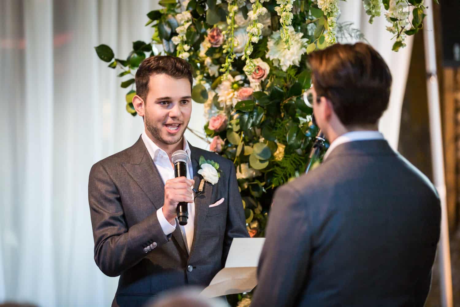 Greenpoint Loft wedding photos of groom saying vows into microphone during ceremony
