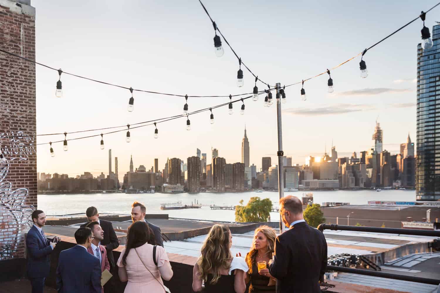 Greenpoint Loft wedding photos of guests enjoying cocktail hour on roof at sunset