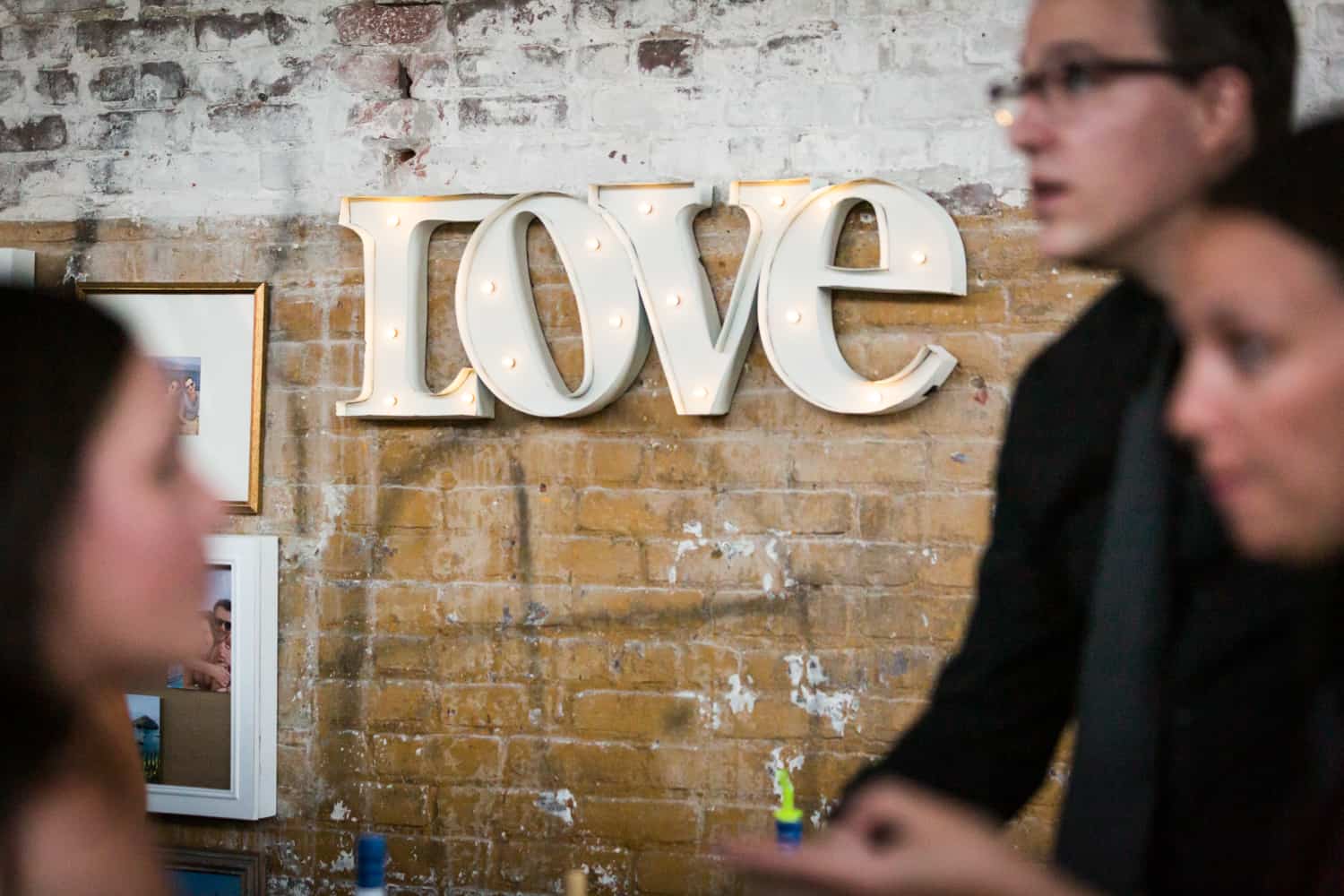'Love' sign on brick wall with lights