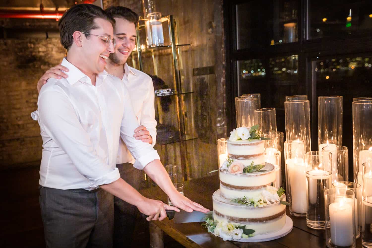 Greenpoint Loft wedding photos of two grooms cutting wedding cake