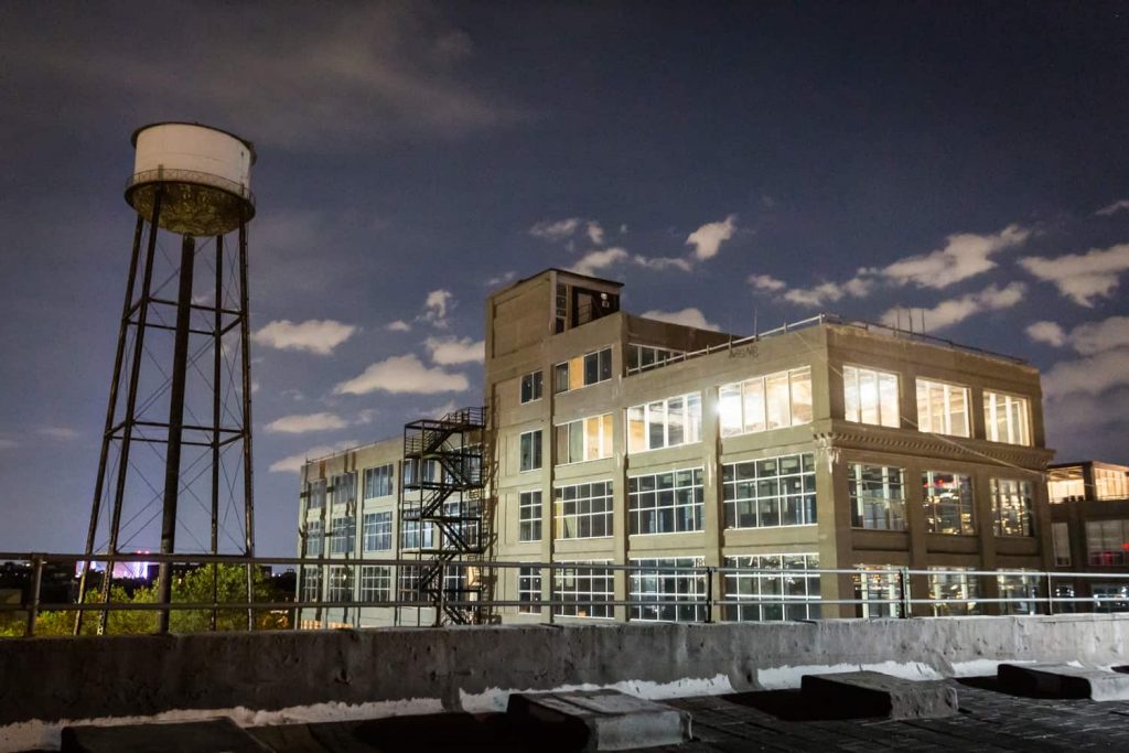 View of Greenpoint, Brooklyn factory building and water tower at night