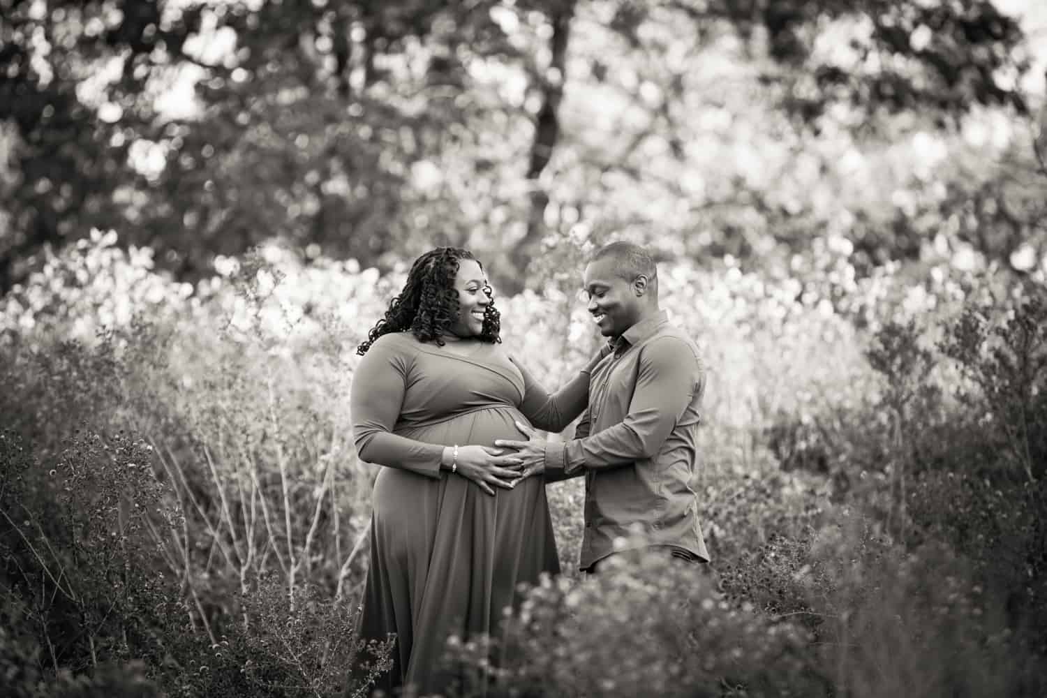 Black and white photo of African American couple during maternity photo shoot in Forest Park