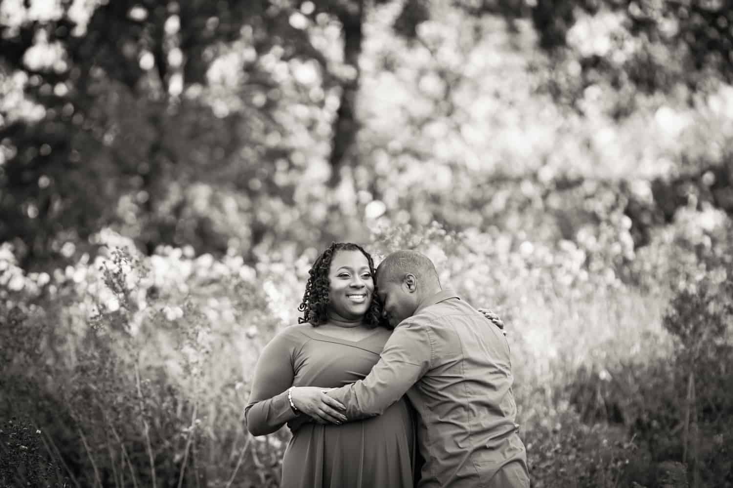 Black and white photo of African American couple cuddling in Forest Park