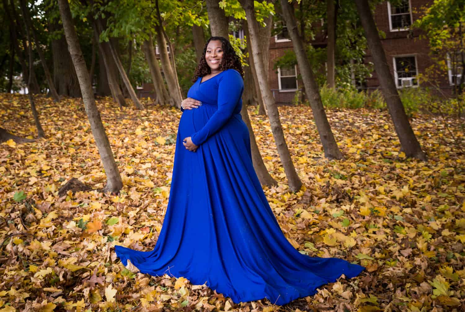 African American pregnant woman wearing blue dress in Forest Park