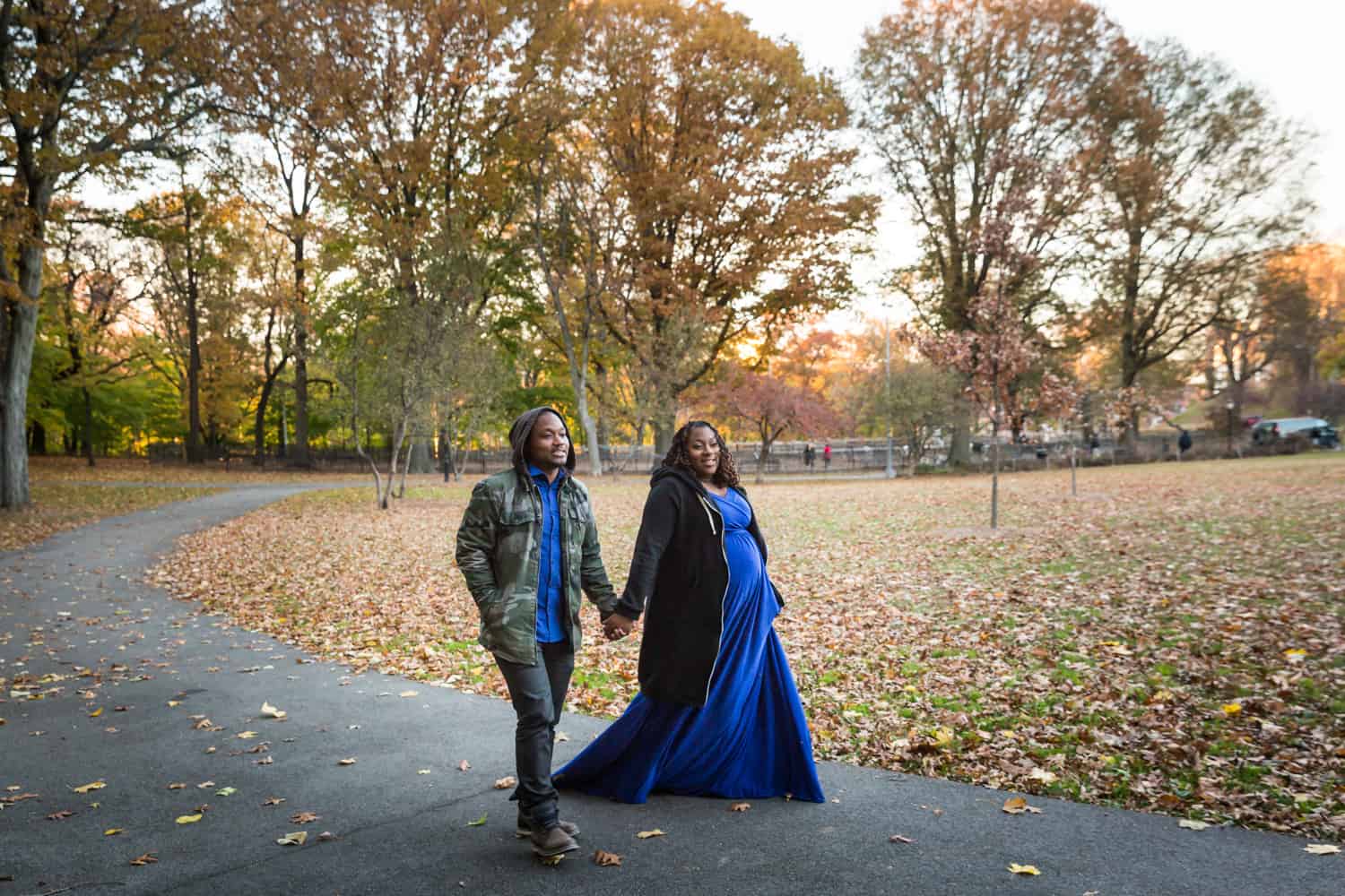 African American couple walking in Forest Park for an article on maternity photo shoot ideas