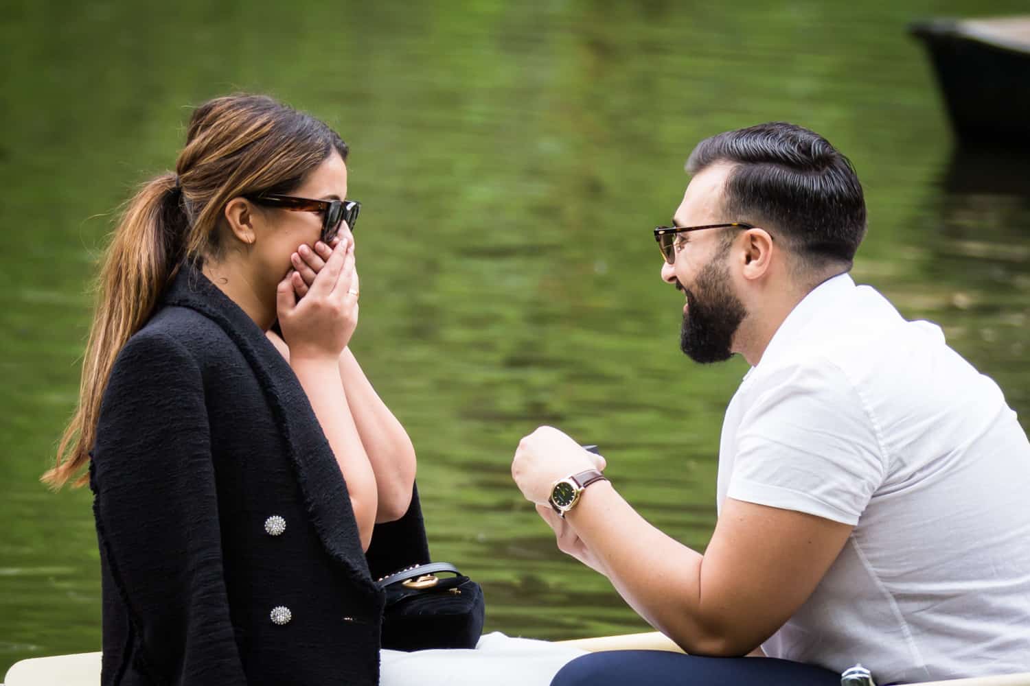 Woman gasping in surprise at a surprise proposal on Central Park Lake
